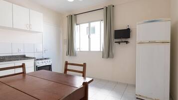 A kitchen with white cabinets, a stove, and a dining table with chairs.