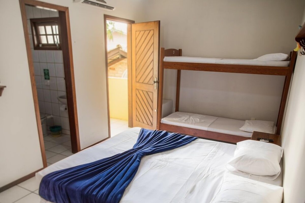 A bedroom with a bunk bed and a single bed, both with white bedding.