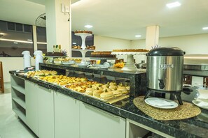 Un bufé con diferentes opciones de comida y una estación de café.