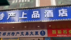 Une enseigne d’hôtel avec des caractères chinois sur un fond bleu.
