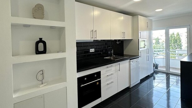A modern kitchen with white cabinetry, black countertops, and a black tiled floor. - Ceazltina Lima Group Guest House (Agualva-Cacém)