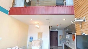 A modern apartment with a balcony, a kitchen with a TV, and a dining area. - Yi Ju Hotel Apartments (Tianjin)