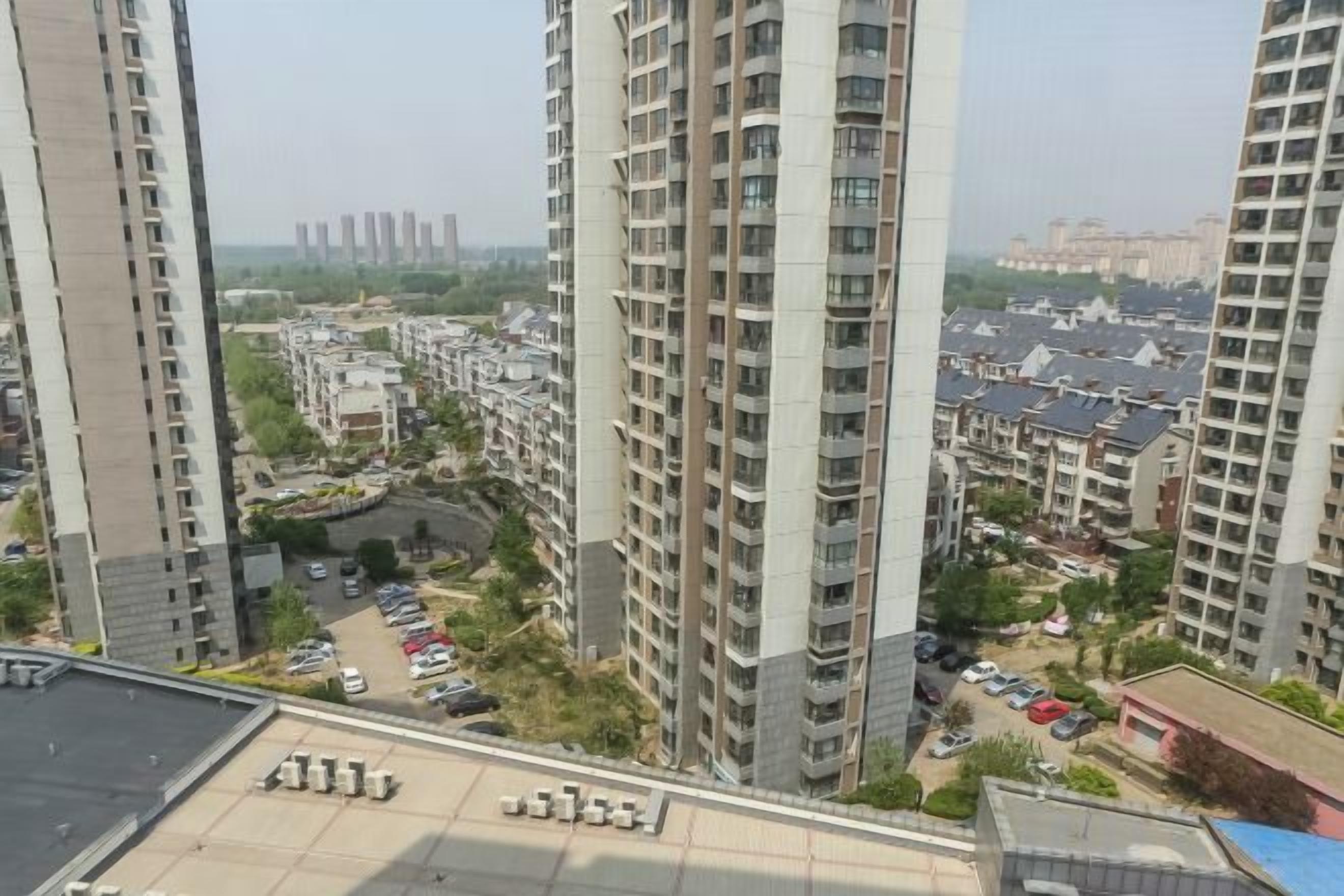 A high-rise building with multiple floors, surrounded by other residential buildings.