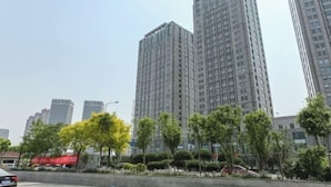 A high-rise building with a modern architectural design, surrounded by greenery and other high-rise buildings. - Yi Ju Hotel Apartments (Tianjin)