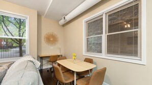 Un comedor con una mesa, sillas, un adorno en la pared y una ventana con persianas.