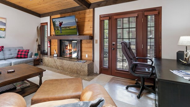 A cozy living room with a fireplace, comfortable seating, and a television. - Spacious Townhome on Shuttle Route, Just Minutes to Vail Resort! (Vail)