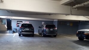 Un parking où trois voitures sont garées dans des emplacements prévus à cet effet.