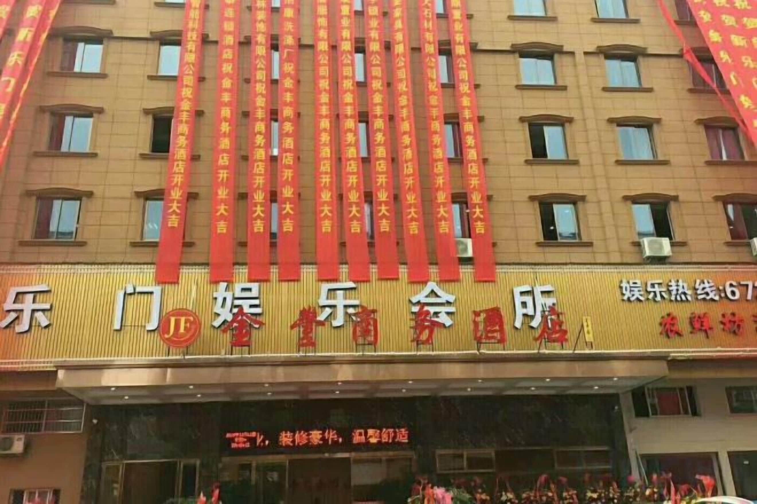 Fachada de hotel con varias ventanas y un letrero con caracteres chinos.
