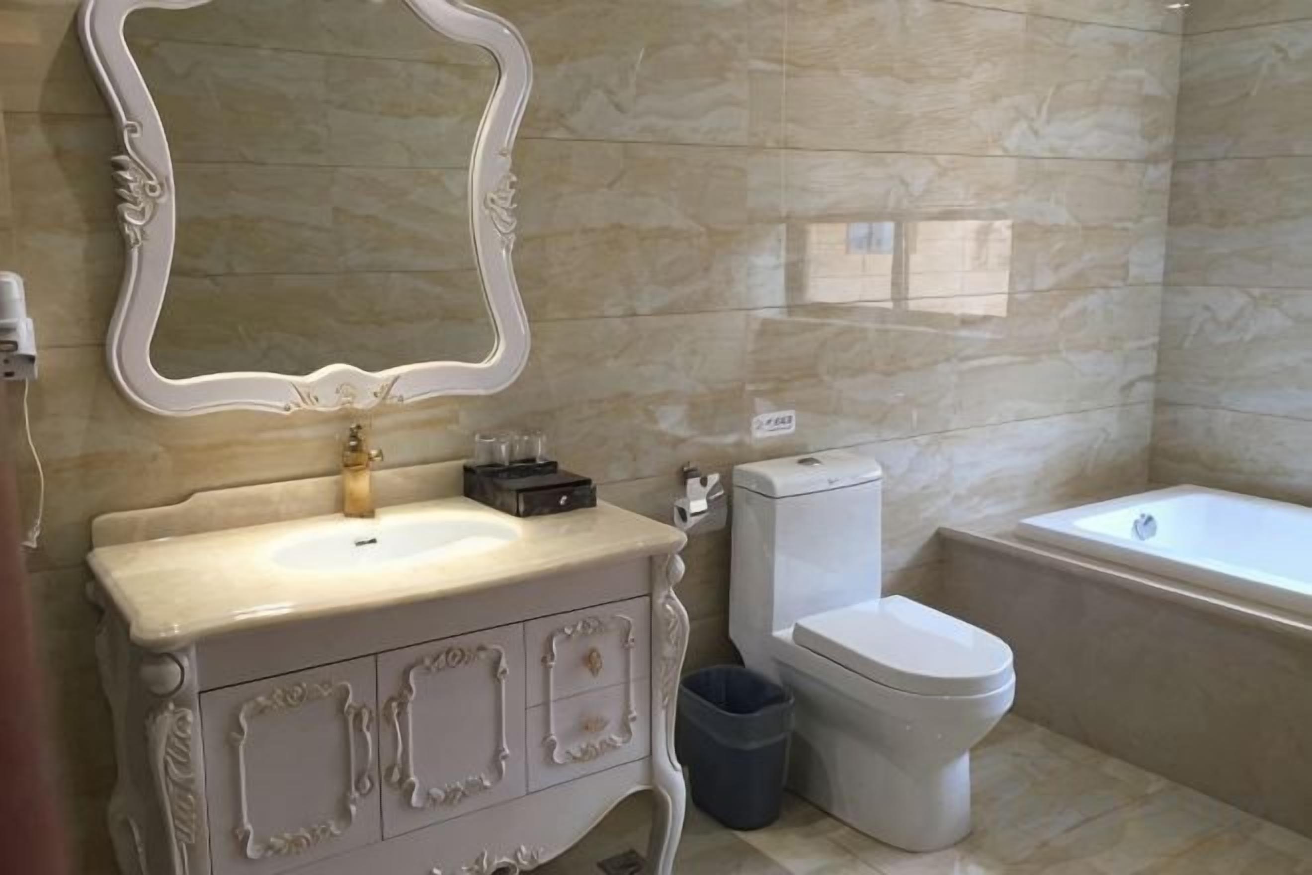 A bathroom with a marble sink, a toilet, and a bathtub.
