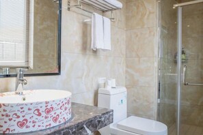 Een badkamer met een marmeren wastafel, een toilet en een douchecabine van glas.