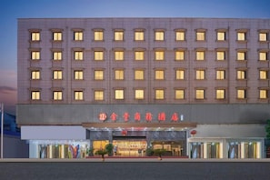 A multi-story hotel with a row of uniformly lit windows and a prominent entrance with signage. - Wenzhou Jinfeng Business Hotel (Yongjia)