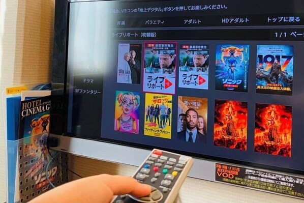 A television screen displaying a movie selection menu with various film posters. - Hotel Airway (Naha)