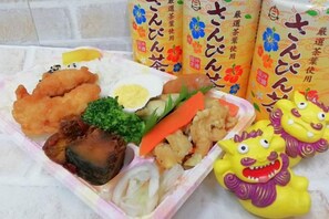 Eine Mahlzeit mit verschiedenen Gerichten, darunter frittierte Speisen, Gemüse und ein gekochtes Ei.