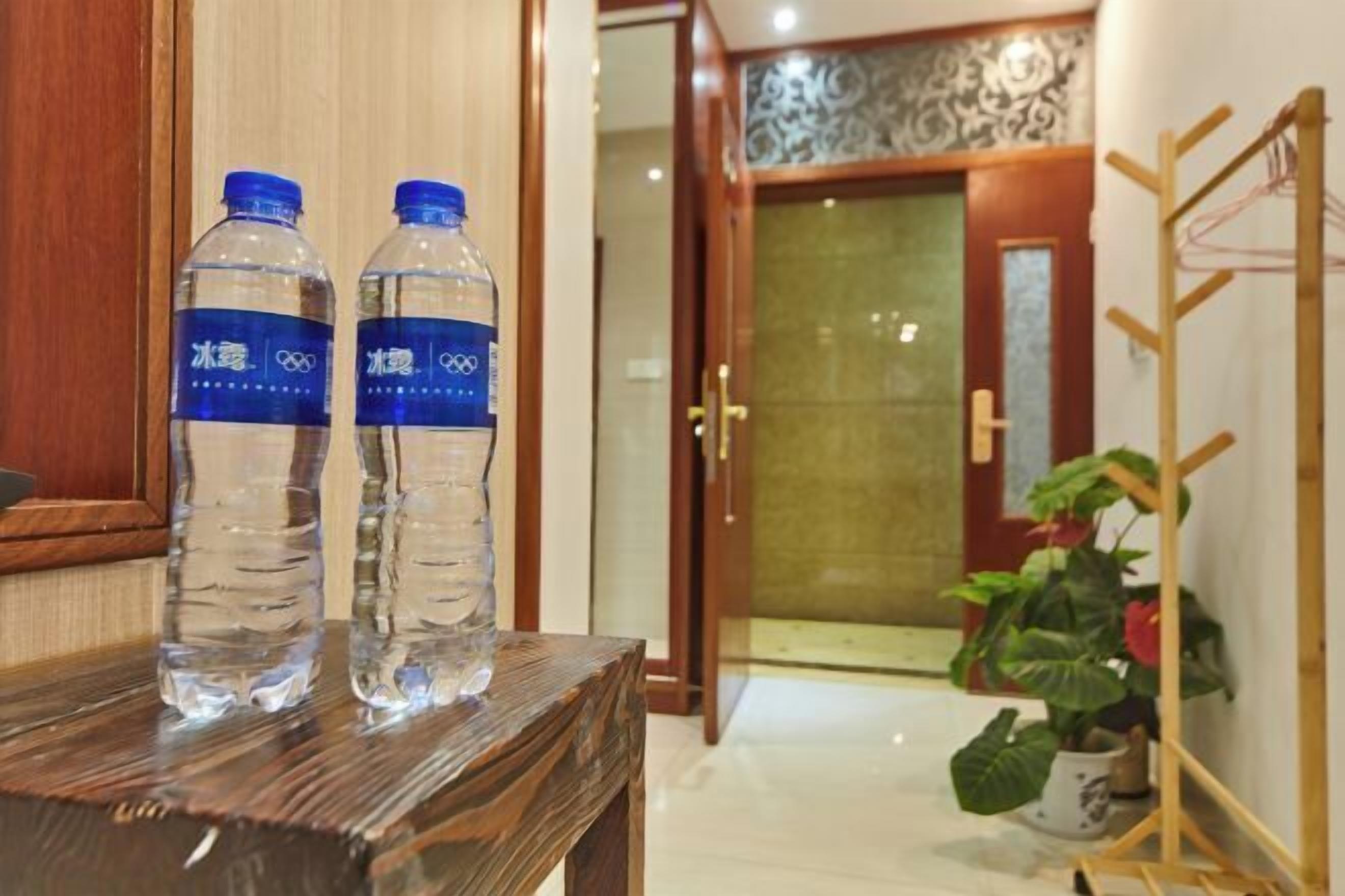 Deux bouteilles d’eau sur une table en bois dans le hall d’un hôtel.