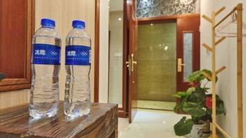 Deux bouteilles d’eau sur une table en bois dans le hall d’un hôtel.