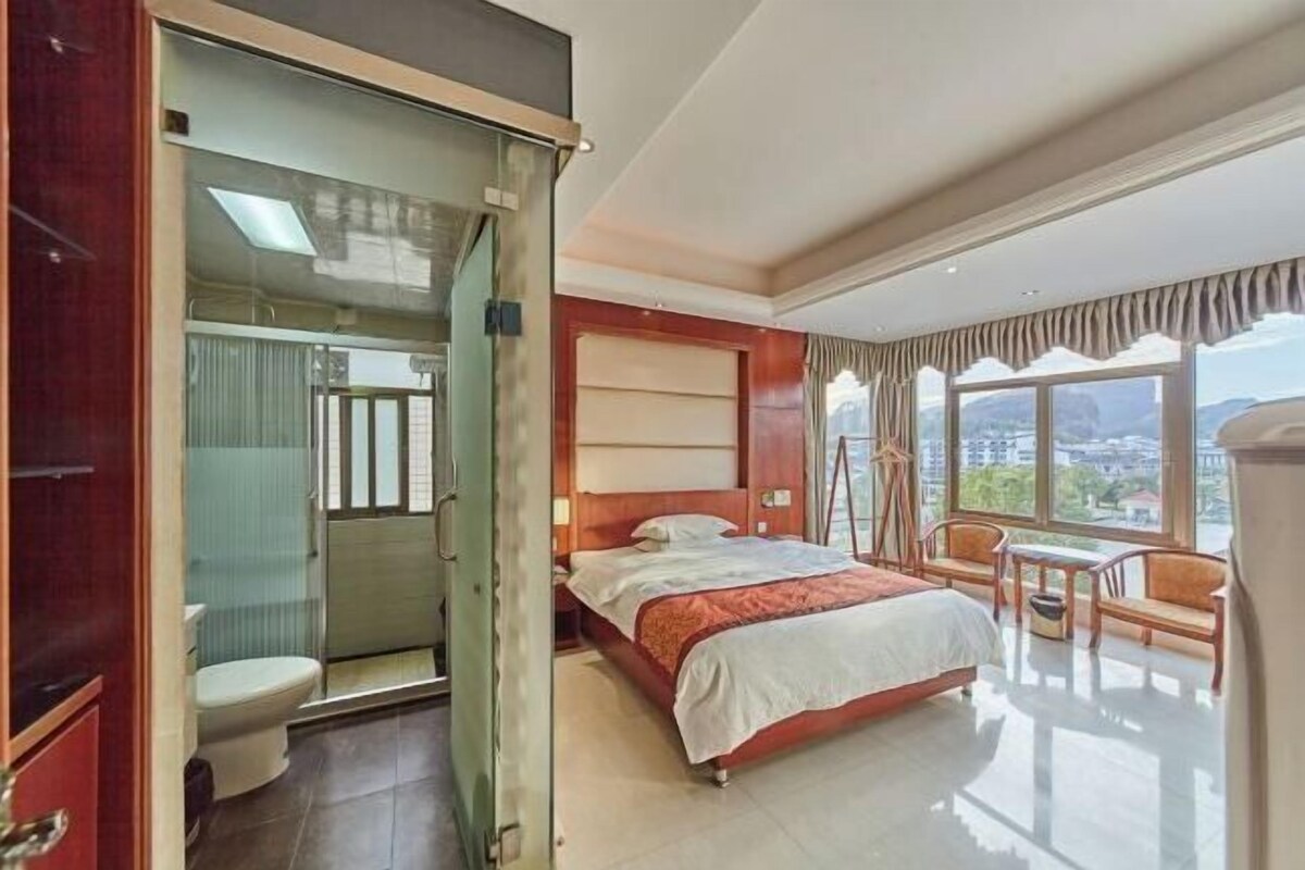 Ein Hotelzimmer mit Bett, Schreibtisch und Blick auf die Stadt.