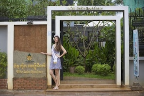 A person standing at the entrance of a building with a sign that reads 'Thai Suan Readiness.'