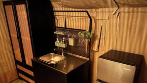 Una cocina compacta con un lavamanos, un refrigerador y una pequeña encimera.