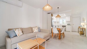 Una sala de estar moderna con un sofá, una mesa de centro y un comedor con sillas y una mesa.