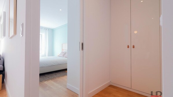 A bedroom with a bed, a wardrobe, and a door leading to another room. - Good Vibes Only by LovelyStay (Porto)