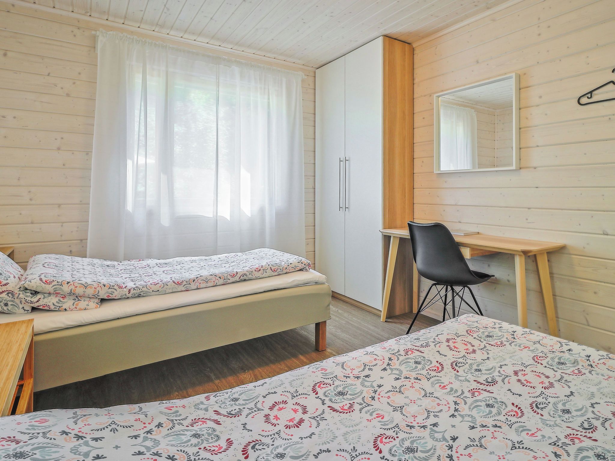 Un dormitorio con una cama, un escritorio y un armario.