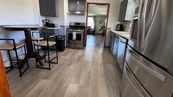 A modern kitchen with a central island, stainless steel appliances, and a ceiling fan.