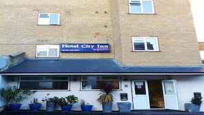 Un immeuble de deux étages avec une enseigne indiquant « Hôtel City Inn ».