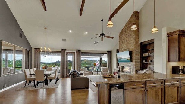 Una cocina amplia con una isla grande, armarios de madera y una pared decorativa de piedra.