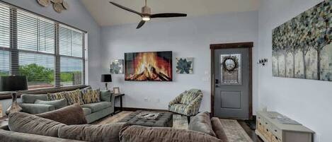 A modern living room with a sectional sofa, a fireplace, and artwork on the walls.