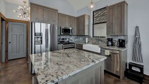 A modern kitchen with granite countertops, stainless steel appliances, and wooden cabinets. - West End Nest With Hot Tub! (Fredericksburg)