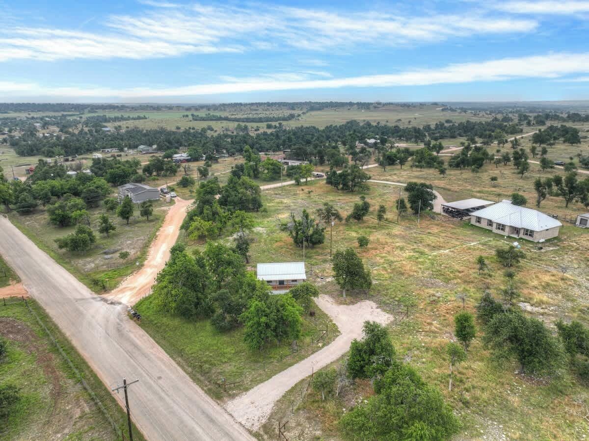A rural landscape with a road, scattered houses, and open fields.