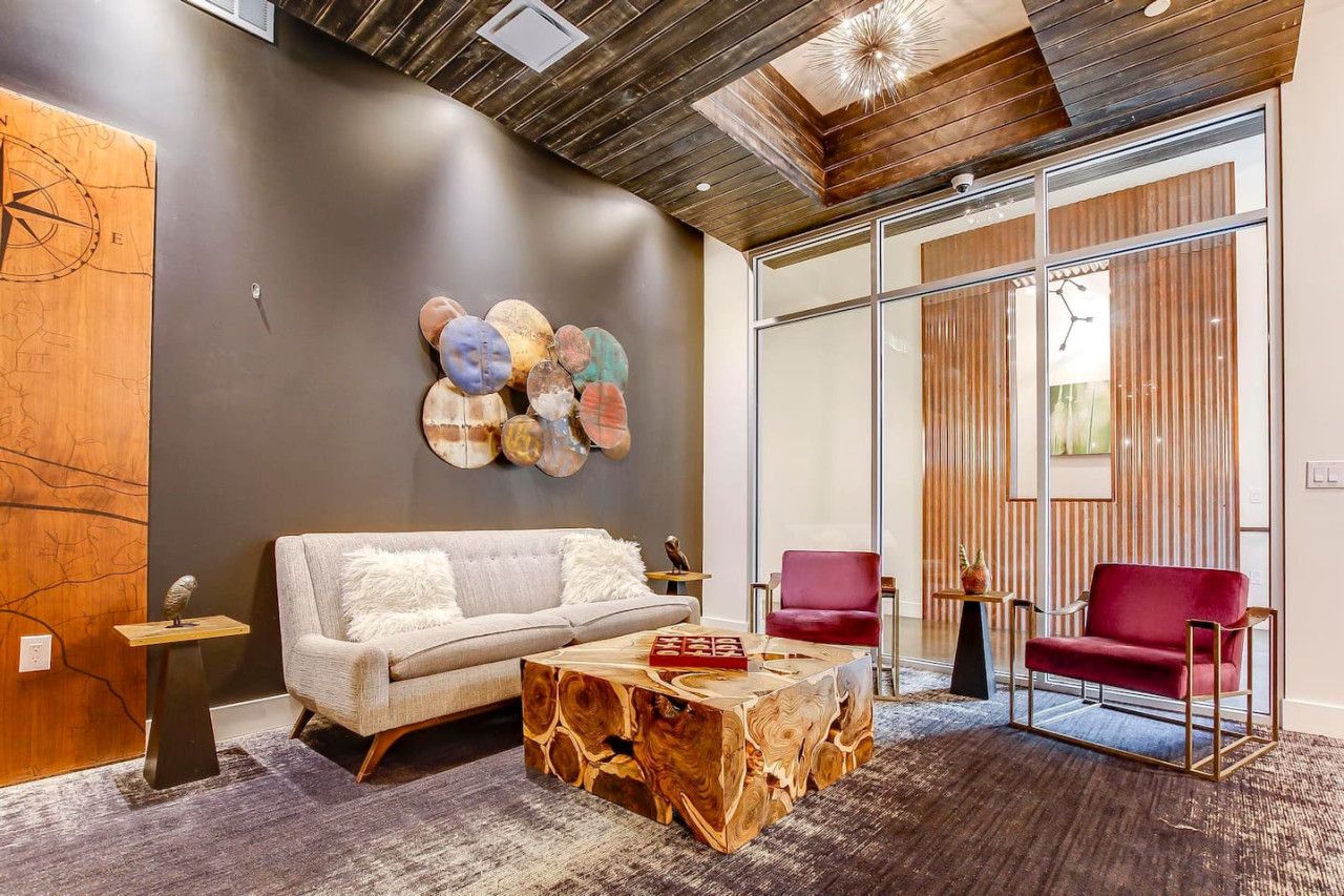 A modern living room with a sofa, a coffee table, and two chairs.