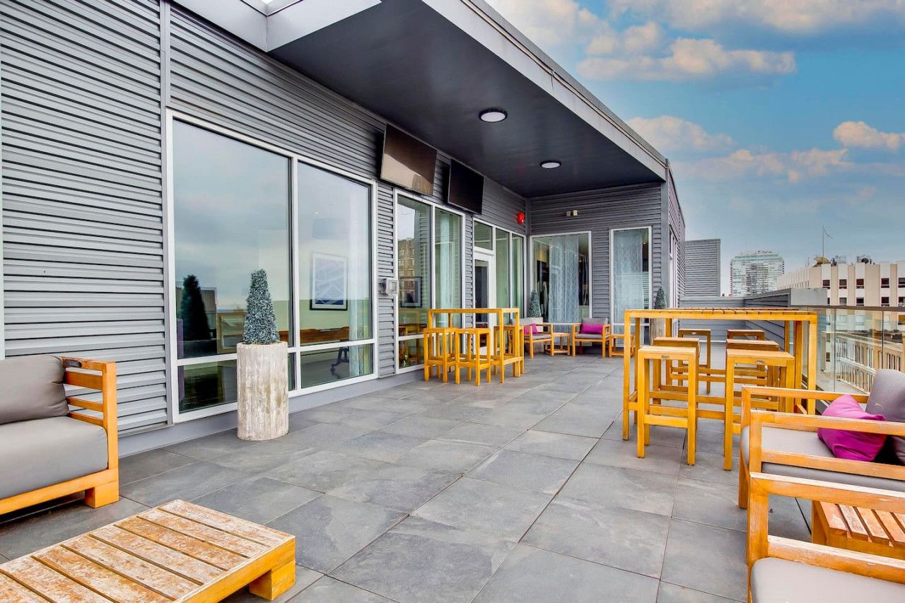 An outdoor seating area with wooden furniture and a modern building facade.