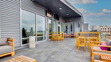 An outdoor seating area with wooden furniture and a modern building facade.