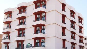 Un hôtel à plusieurs étages doté d’une architecture remarquable, avec des balcons et des unités de climatisation.