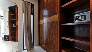 A room with a wooden wardrobe, a shelf unit, and a curtain. - Luxury - Villa Ron - Central Seminyak (Bali)