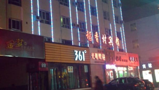A building with illuminated signs, including one with "361" and another with Chinese characters.