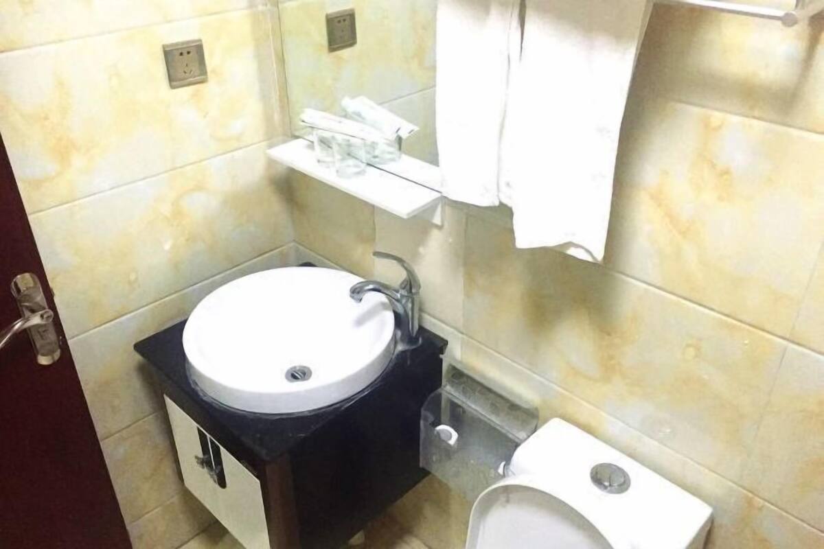 A bathroom with a sink, mirror, and toilet.