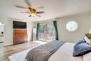 A bedroom with a bed, a dresser, a television, and a ceiling fan. - Sandy East Bench • Pool • Mountain Views • Hot Tub (Sandy)