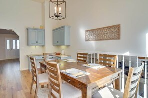 A dining area with a wooden table, chairs, and a chandelier.