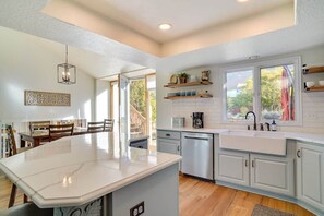 A modern kitchen with a central island, built-in appliances, and a large window providing natural light. - Sandy East Bench • Pool • Mountain Views • Hot Tub (Sandy)
