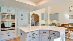A kitchen with light blue cabinets, a large island, and a built-in microwave. - Sandy East Bench • Pool • Mountain Views • Hot Tub (Sandy)