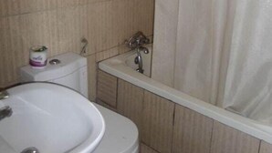 A bathroom with a toilet, sink, and bathtub. - Chinox Guest Inn (Abuja)