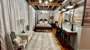 A bedroom with a large bed, a desk, a chair, and a mirror. - Room 2 (sleeps 2) at Chipley's Squareview Inn (Carthage)
