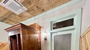 A wooden elevator with a metal door, a potted plant, and a white door with the number 5. - Room 2 (sleeps 2) at Chipley's Squareview Inn (Carthage)