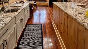 A kitchen with wooden beams, granite countertops, and a brick wall. - Room 4 (sleeps 2) at Chipley's Squareview Inn (Carthage)