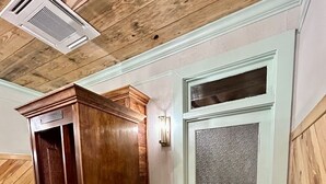 A wooden elevator with a metal door, a potted plant, and a white door with the number 5. - Room 5 (sleeps 2) at Chipley's Squareview Inn (Carthage)