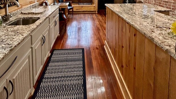 A kitchen with wooden beams, granite countertops, and a brick wall. - Room 5 (sleeps 2) at Chipley's Squareview Inn (Carthage)