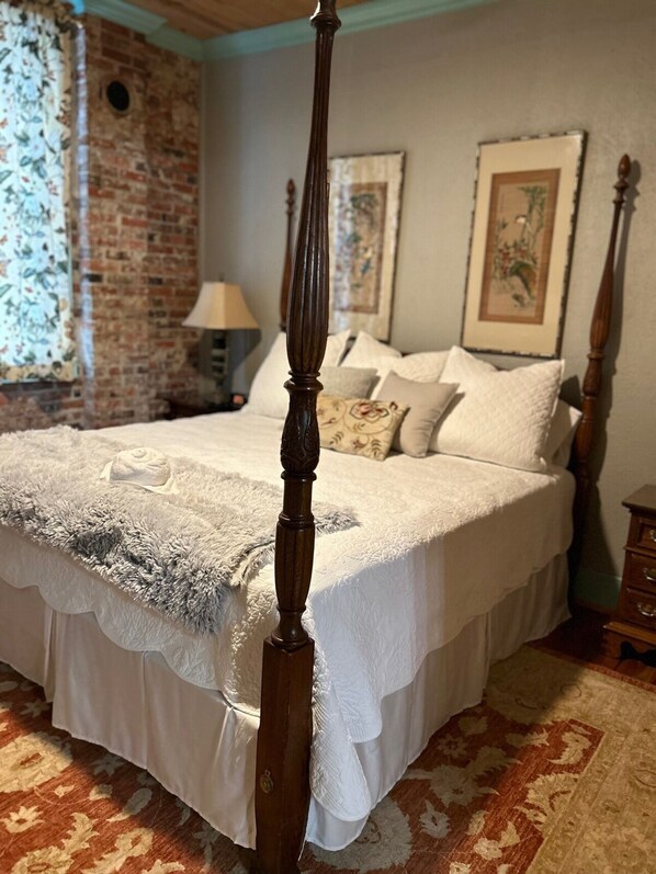 A four-poster bed with a white bedspread and a fluffy white throw blanket. - Room 5 (sleeps 2) at Chipley's Squareview Inn (Carthage)
