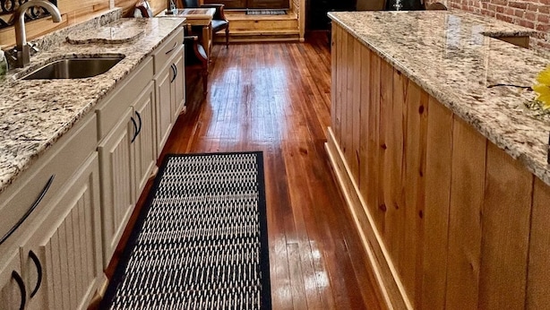 A kitchen with wooden beams, granite countertops, and a brick wall. - Room 6 (sleeps 2) at Chipley's Squareview Inn (Carthage)
